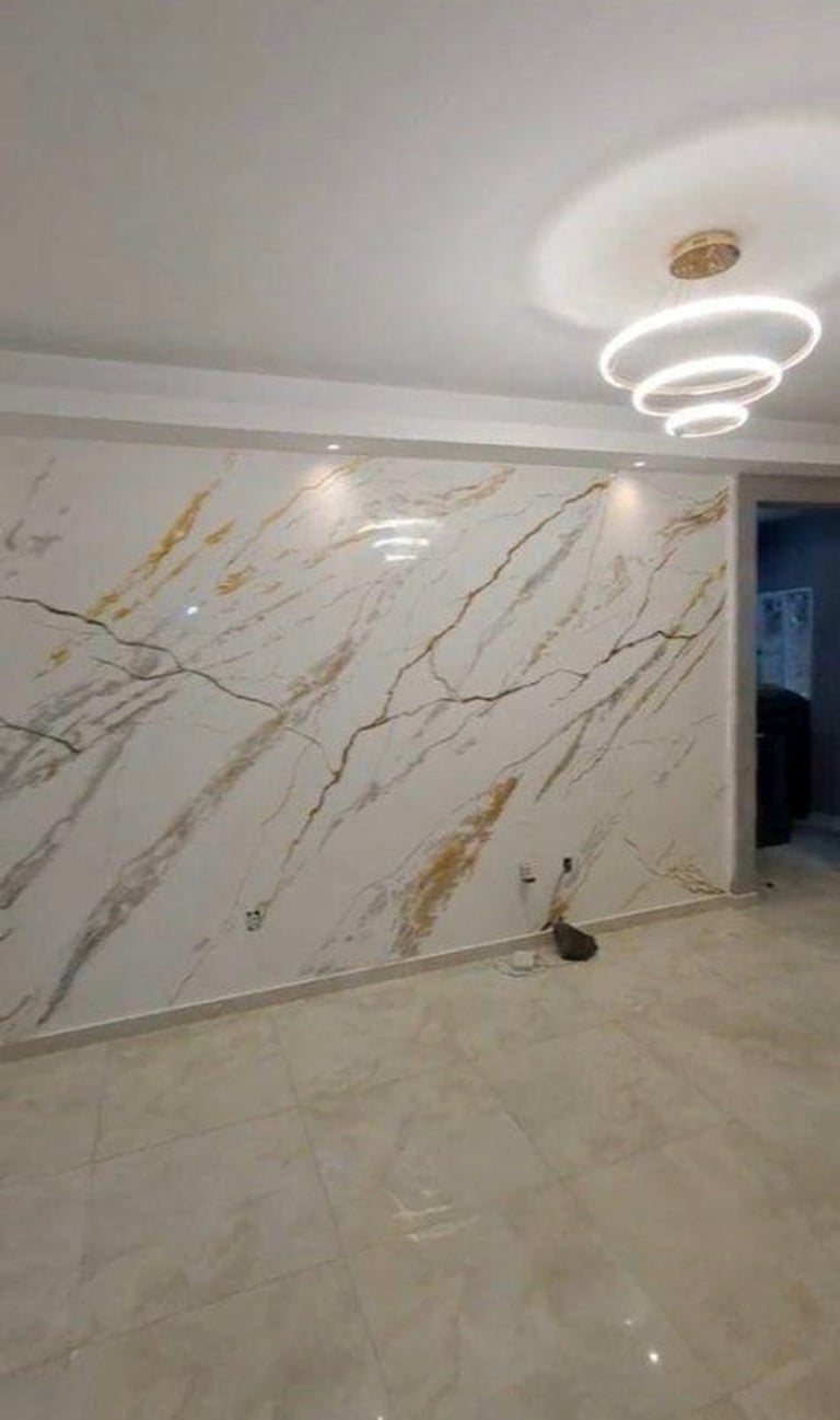 Modern interior space with white marble-textured walls, polished floor, circular LED ceiling fixture, and recessed lighting