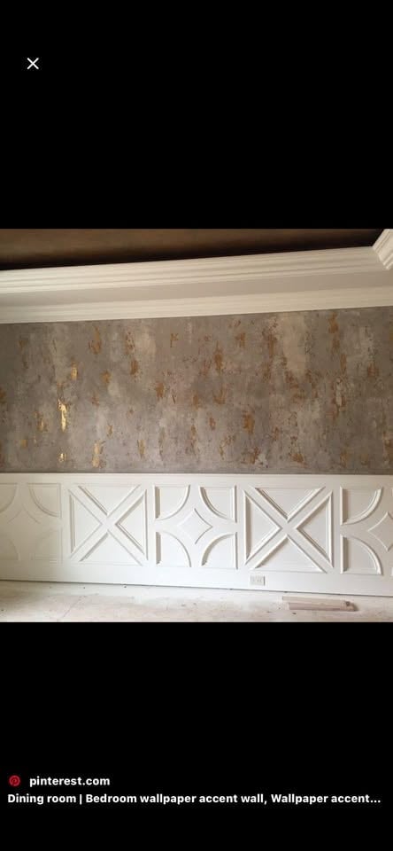 Interior wall with cream geometric wainscoting and textured gray wallpaper accent above, featuring decorative X-pattern molding